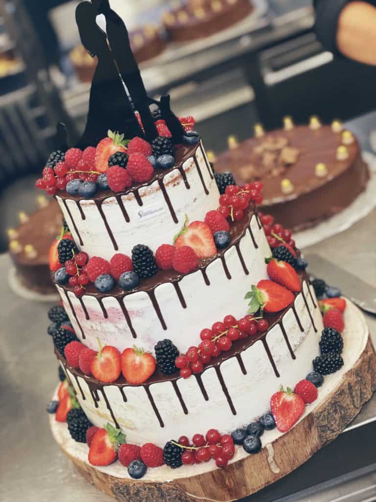 Hochzeitstorte mit frischen Beeren auf Baumscheibe